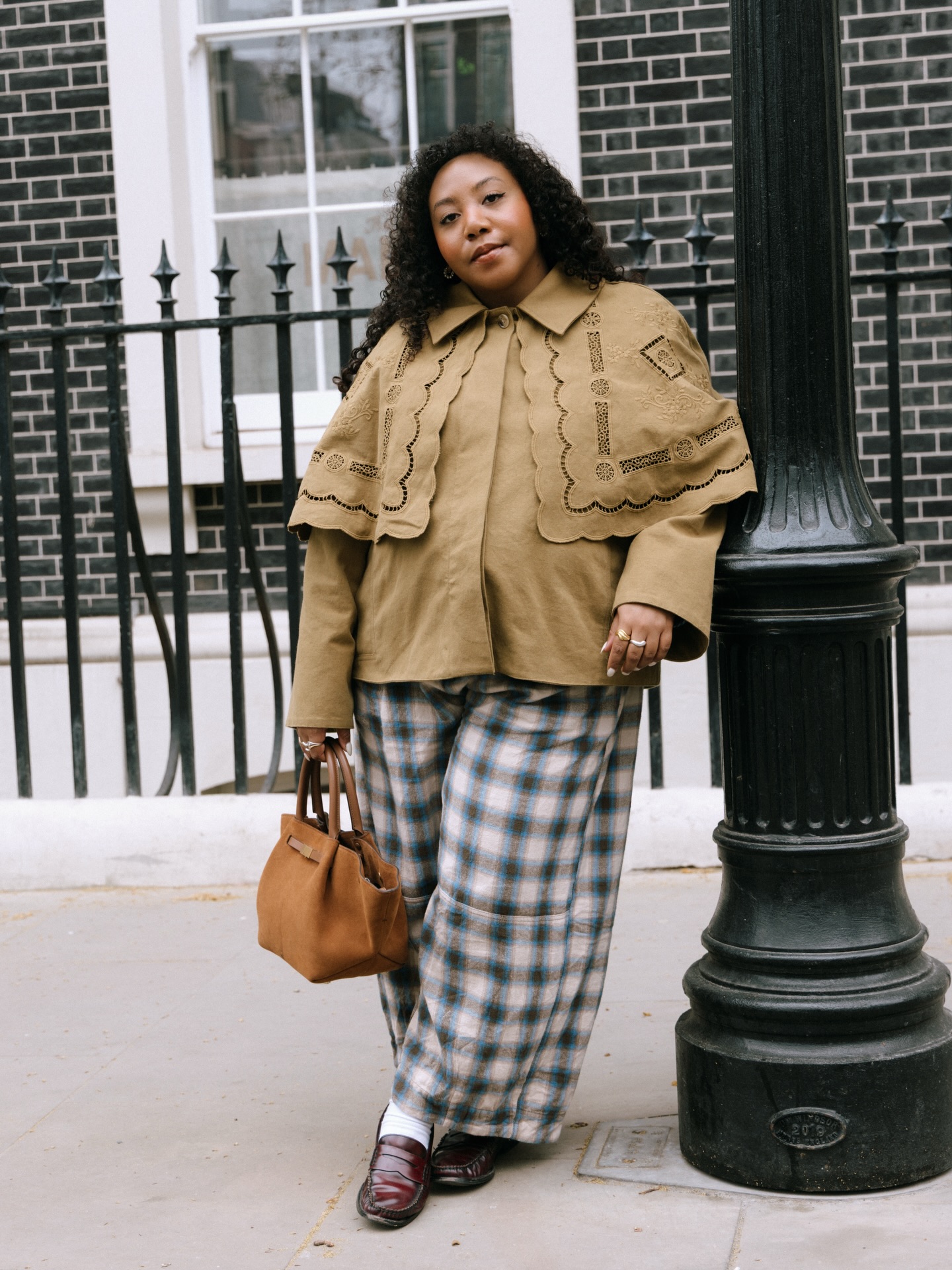 Why a Statement Cape Jacket Can Make Plaid Trousers Feel Instantly More Fashionable